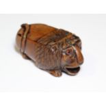 A 19th century coquilla-nut snuff box carved in the form of a crouching lion, with inset glass