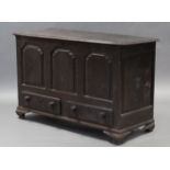 An early 18th century oak mule chest with hinged lift-lid & triple-panel front above two short