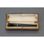 An Asprey diamond-set cigarette holder, the plain sleek black body with narrow white metal band