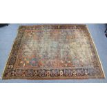 A Persian large rug of crimson ground, the central panel with foliate geometric designs within