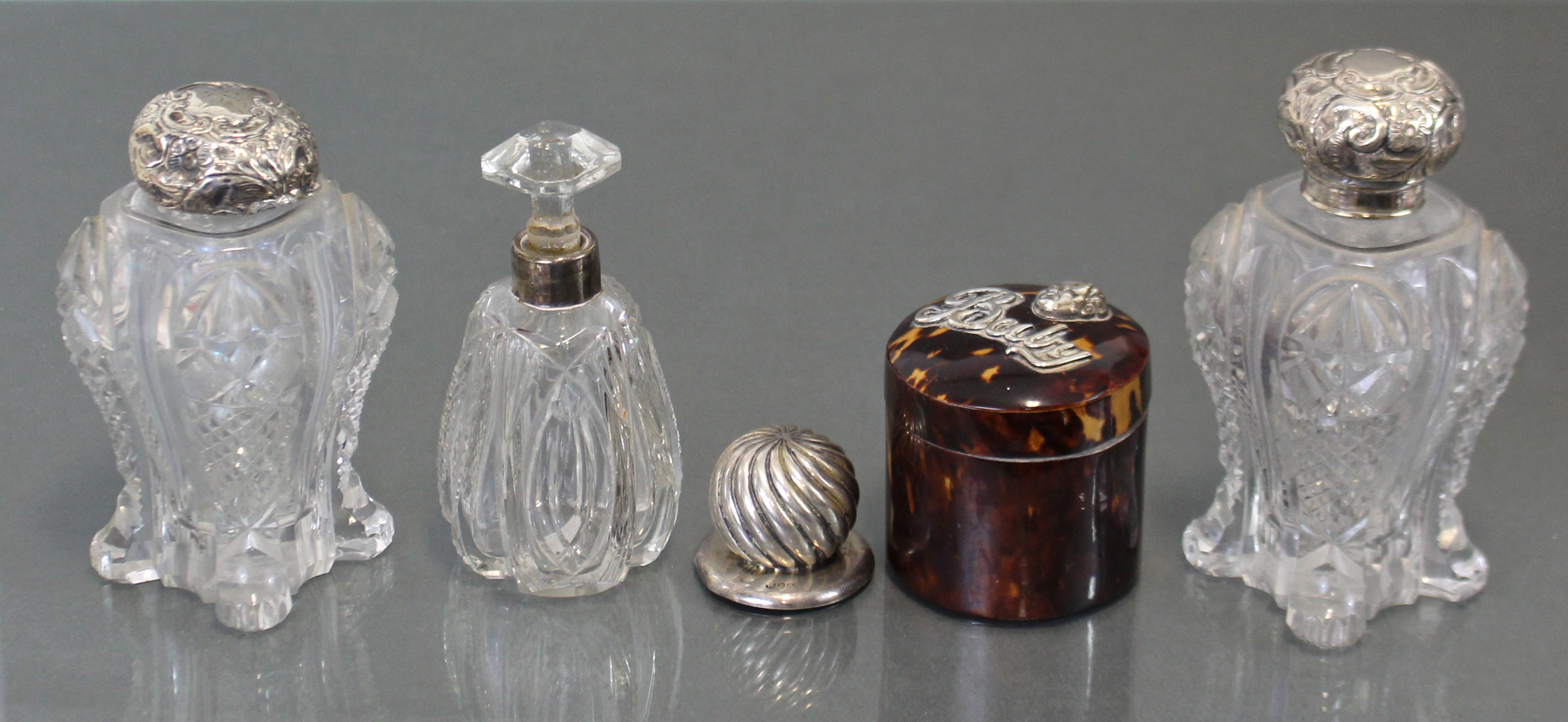 A pair of Edwardian cut glass water bottles with silver lids, London 1903 (w.a.f.); a similar