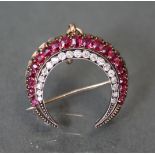 A RUBY, DIAMOND, & GOLD CRESCENT BROOCH/PENDANT set twenty one graduated rubies, enclosing an inner