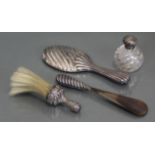 A silver-mounted perfume bottle; a silver-backed hand mirror & similar shoe-horn; & a soft brush