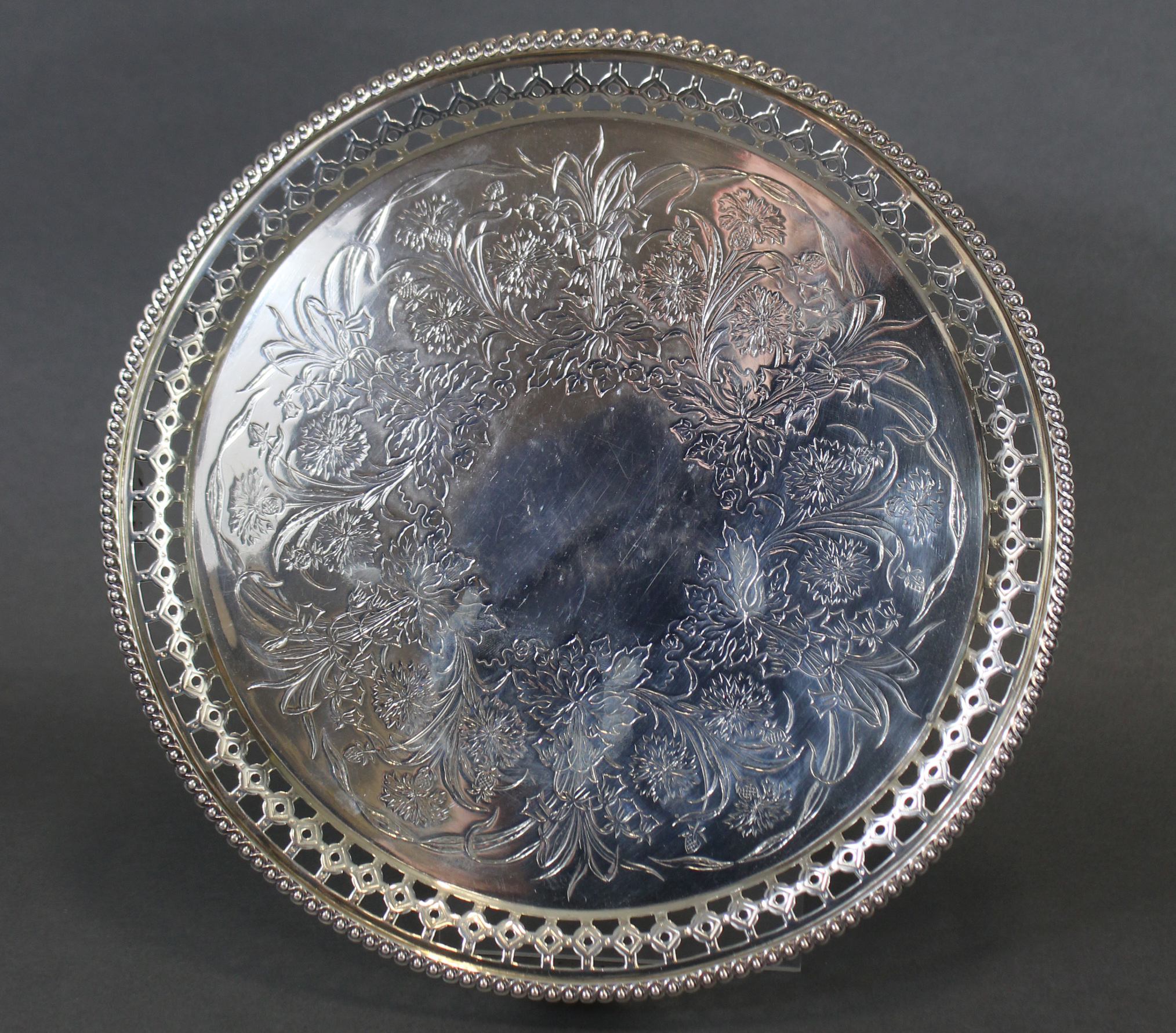 A Victorian silver circular tray with engraved floral decoration, the pierced border with