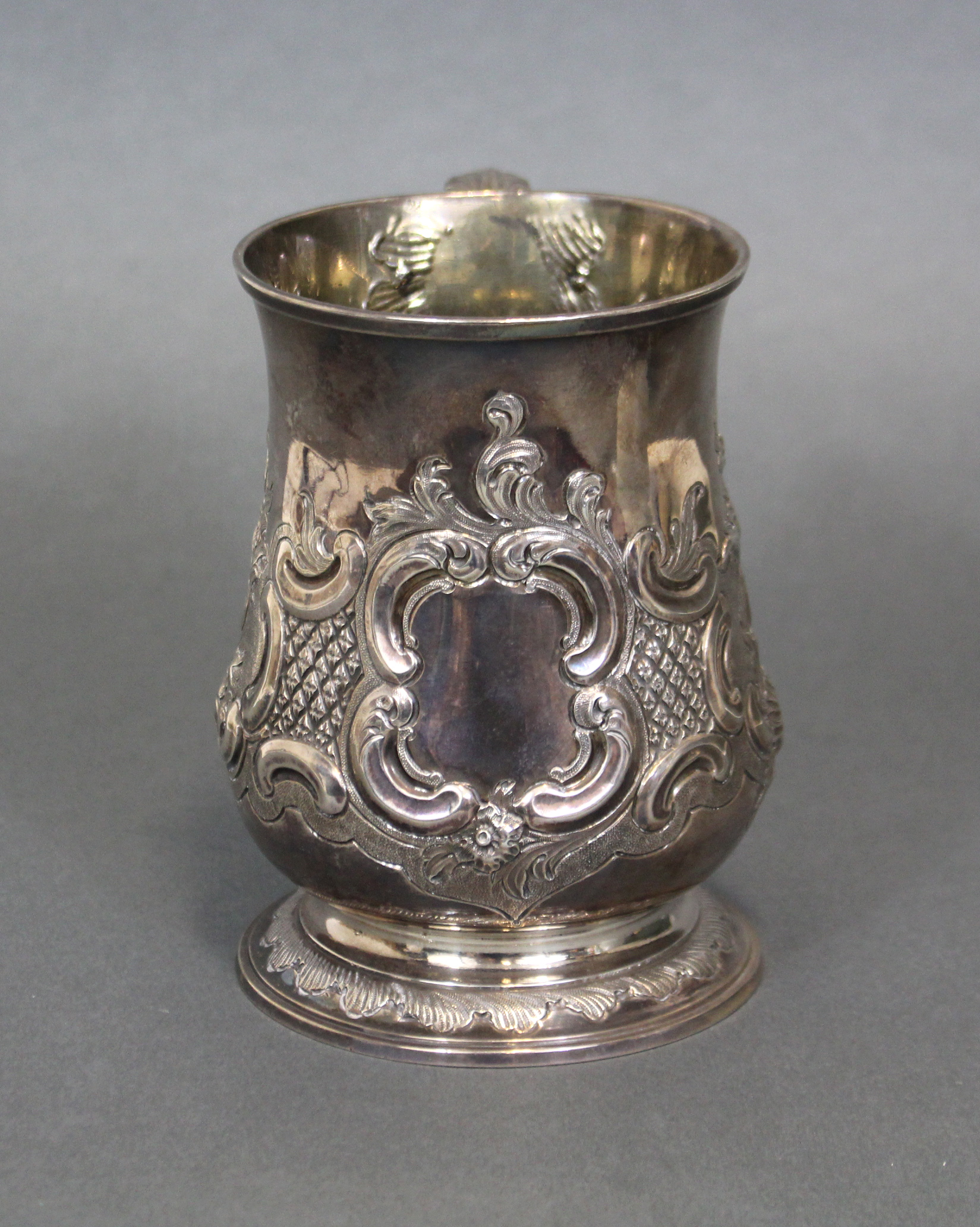 A GEORGE III SILVER TANKARD, the baluster body with embossed decoration of leaf scrolls around a - Image 2 of 5