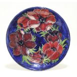 A Moorcroft “Anemone” plate of deep blue ground, painted initials & impressed marks; 10” diam.