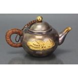 A Chinese heavy silver & yellow metal small teapot of rounded form, with ball finial to the domed