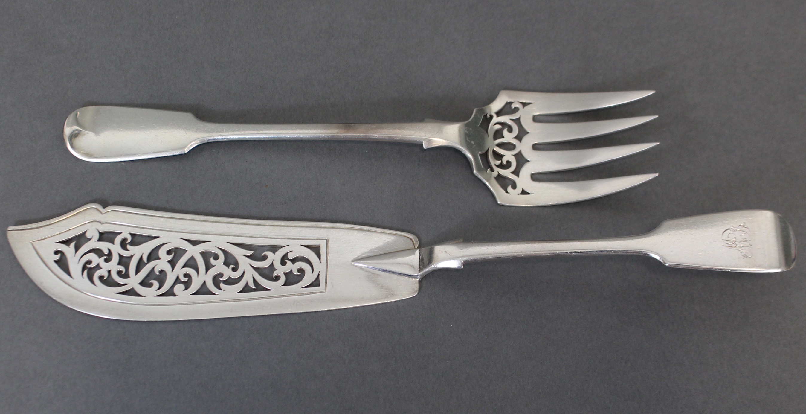 A pair of Victorian silver Fiddle pattern fish servers with pierced scroll decoration, London