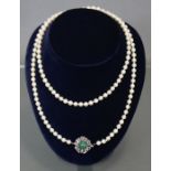 A single row necklace of uniform cultured pearls, each approximately 6mm diam., the white 14K