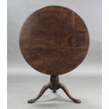A Georgian mahogany tripod table, the plain circular top with birdcage support on gun-barrel