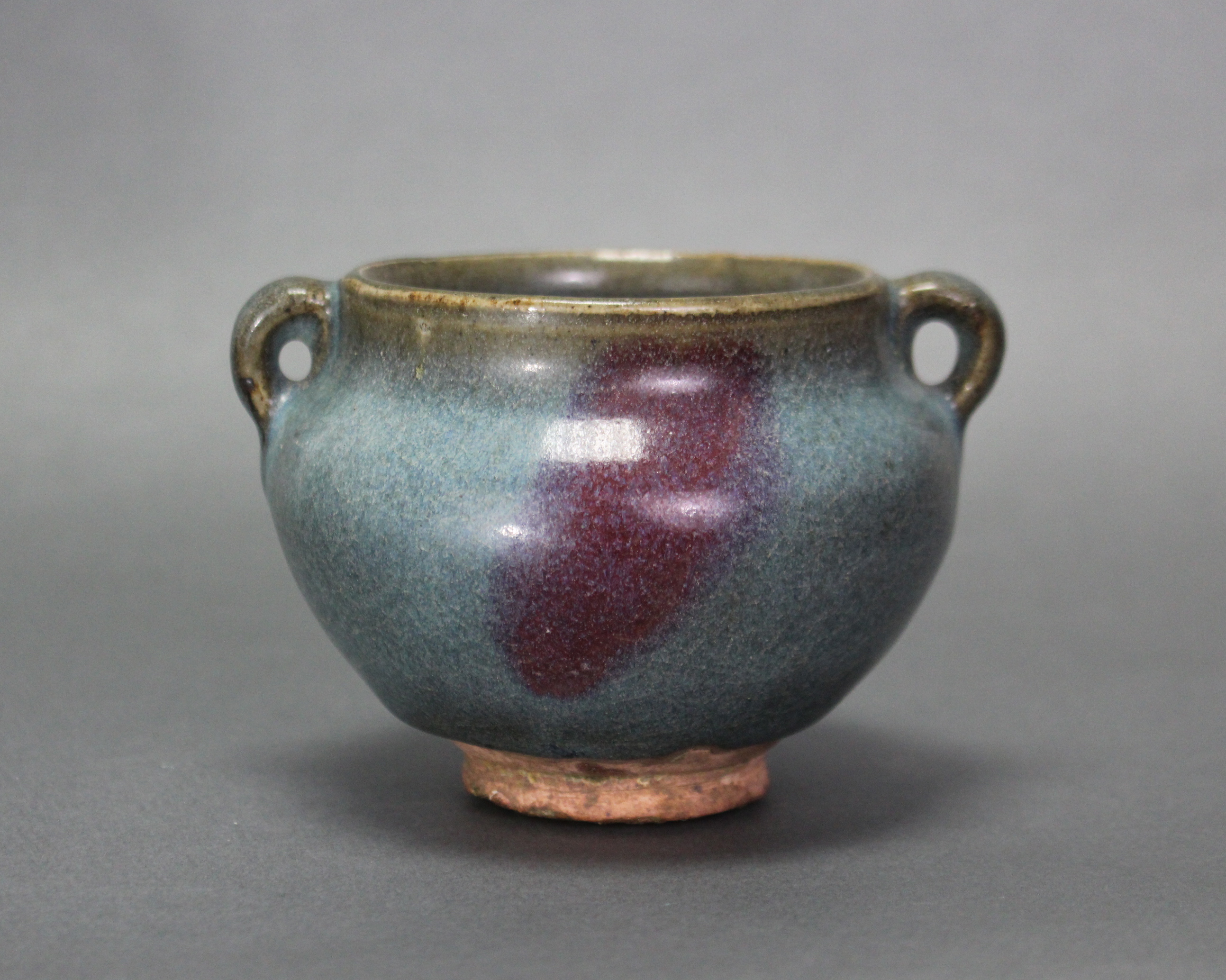 A Chinese Junyao-type pottery jarlet of compressed round form with small ring side-handles, a purple