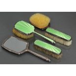 A green enamelled silver-backed five-piece dressing table set comprising: two hair brushes, two