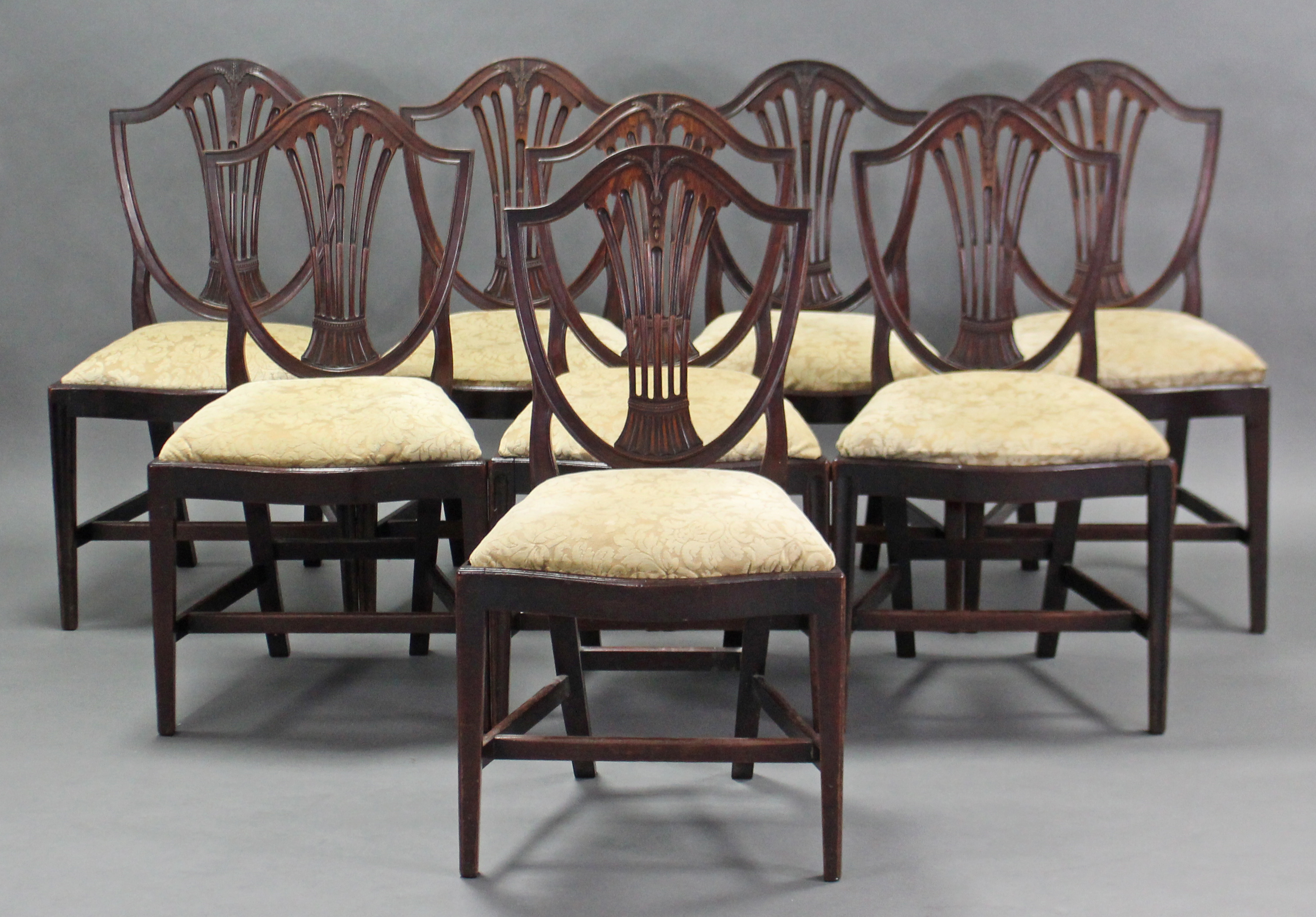 A set of eight 19th century Hepplewhite-style dining chairs, the shield-shaped backs with pierced