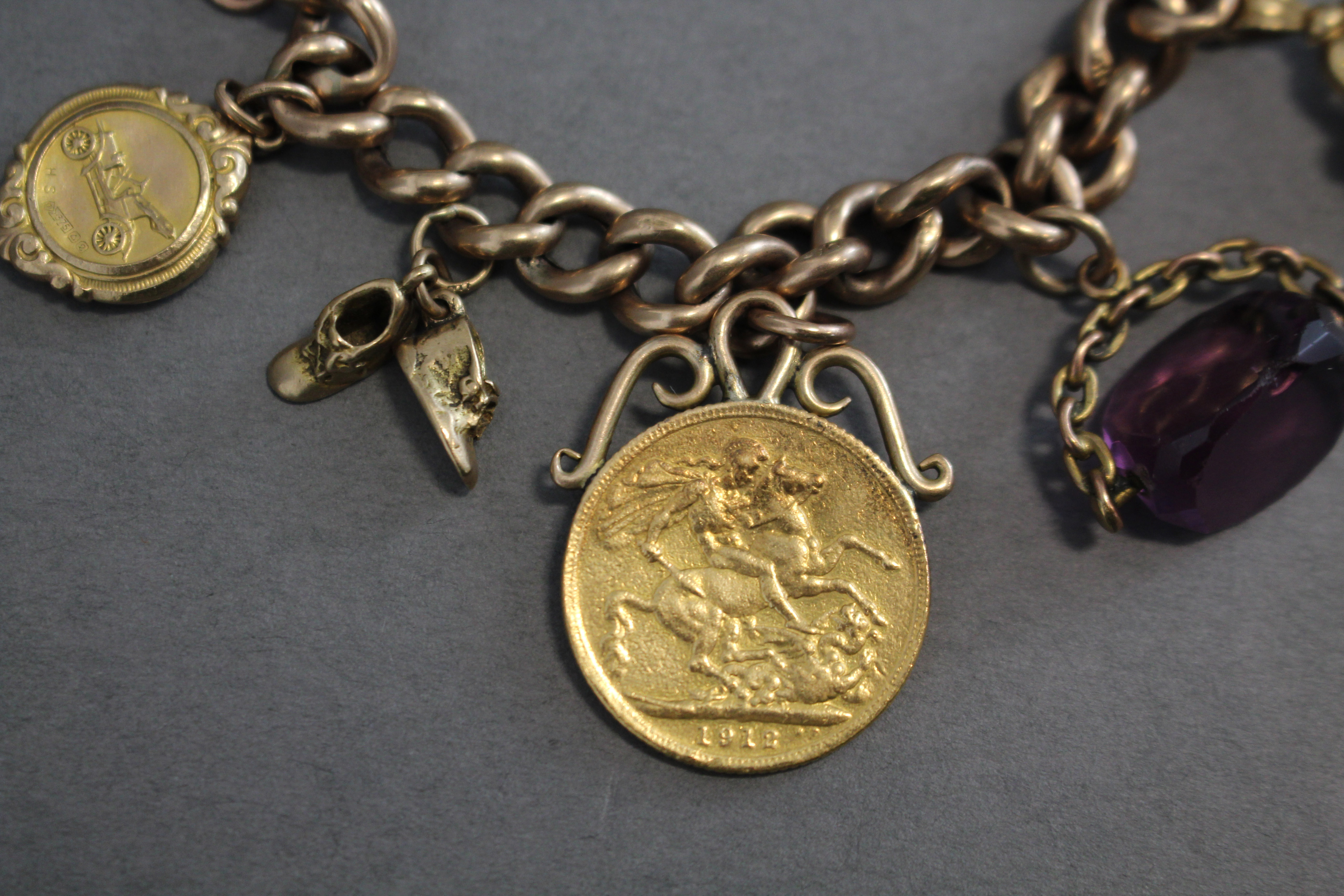 A 9ct. gold curb-link charm bracelet with padlock clasp & safety chain, a pendant George V sovereign - Image 2 of 7