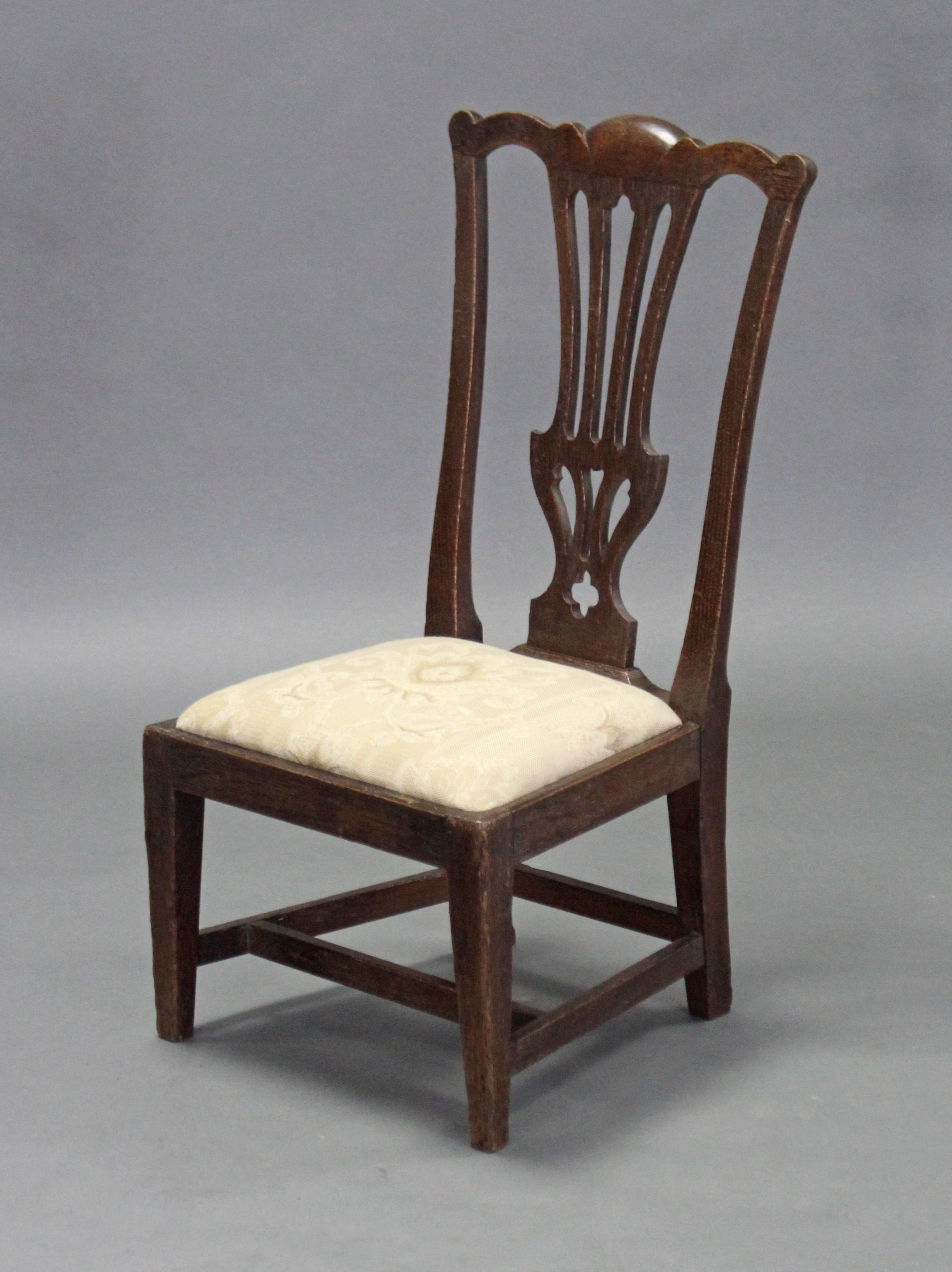 A 19th century Chippendale-style oak child’s chair, with pierced splat to the shaped back, padded