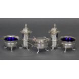 An Edwardian silver five-piece condiment set, each of round shape with card-cut rims & on three