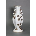 An early Chinese porcelain eight-sided fluted baluster vase, with scroll side handles to the