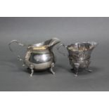 An 18th century style Irish silver cream jug with embossed decoration of animals & foliage, on