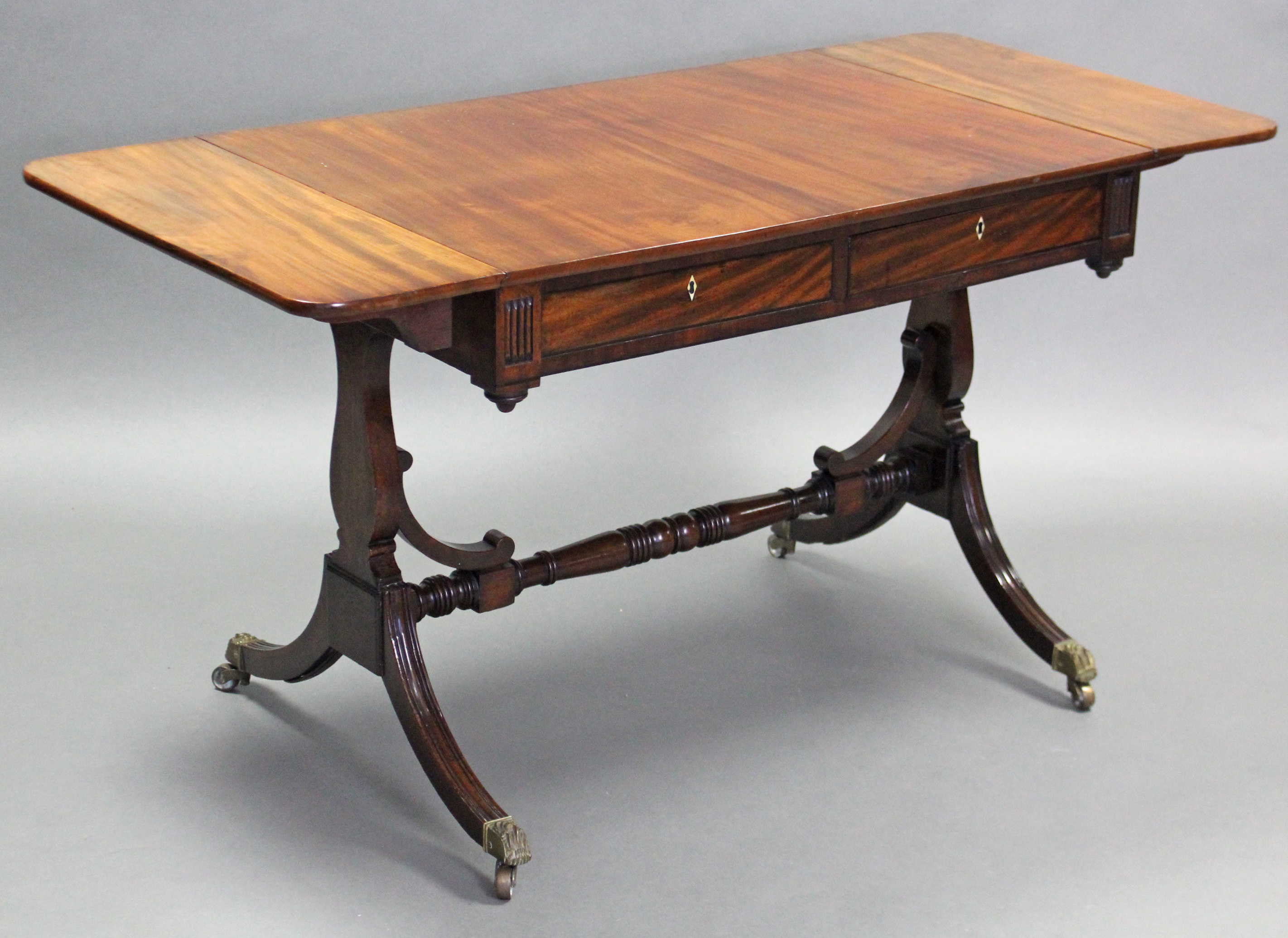 A REGENCY INLAID MAHOGANY SOFA TABLE, the rectangular top with rounded ends to the drop-leaves,