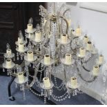 A CUT-GLASS THIRTY-BRANCH CHANDELIER of foliate scroll design, all-over hung with beads & prism