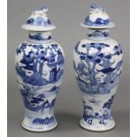 A pair of Chinese blue & white porcelain slender baluster vases & covers, each with river