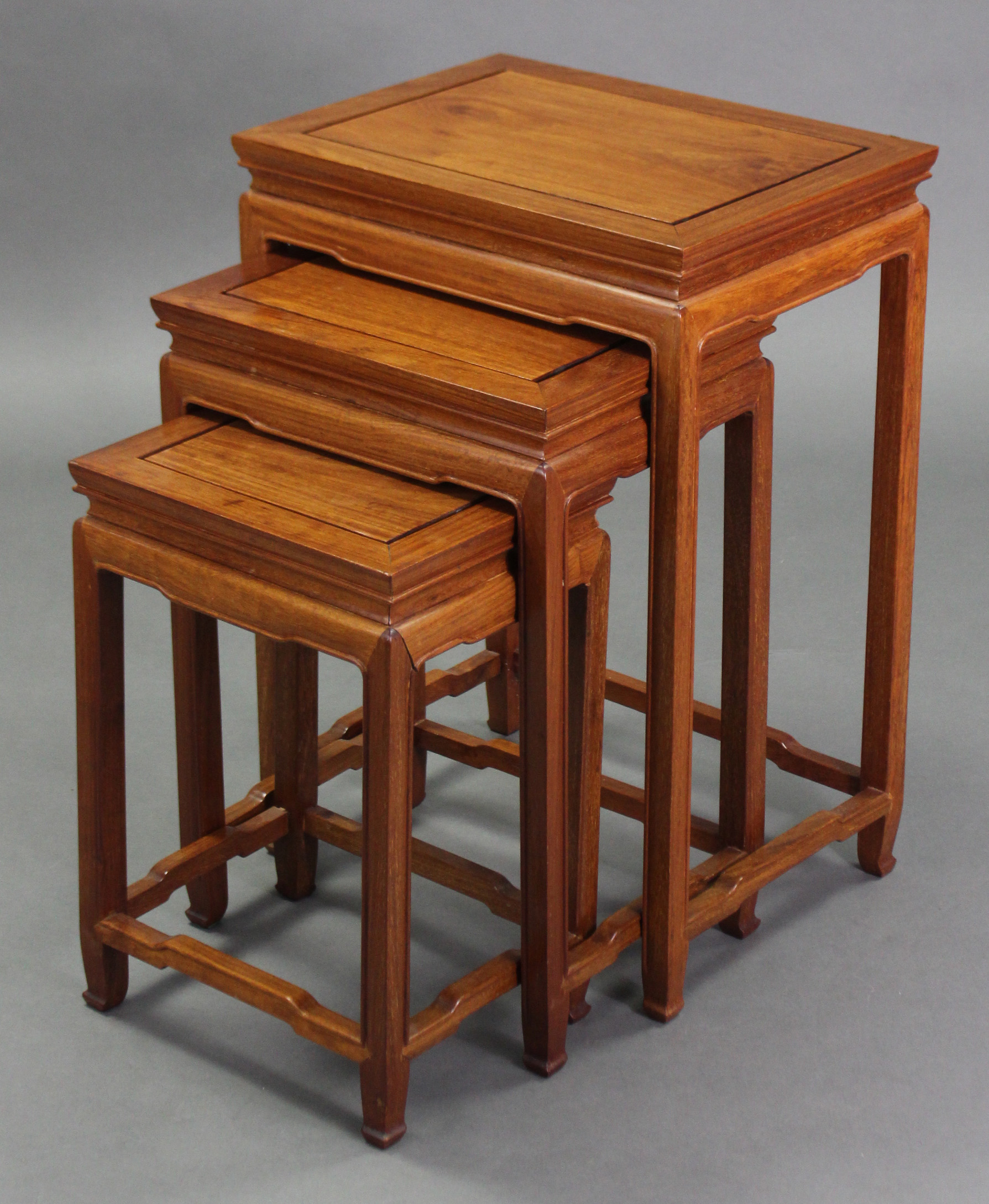 A nest of three Chinese teak occasional tables with shaped friezes & on square legs; 19” wide x