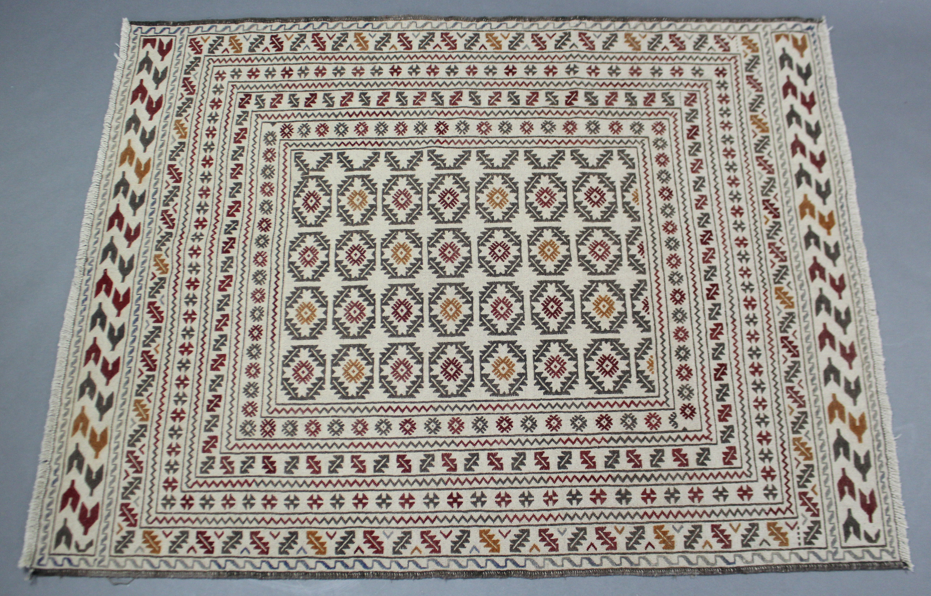 A Sumak needlework kelim rug of ivory ground with red, yellow & green geometric design to centre