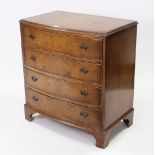 A reproduction walnut bow-front chest, fitted four long drawers with brass swing handles, & on