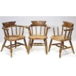 A set of three spindle-back carver chairs with hard seats, & on turned legs with spindle stretchers,
