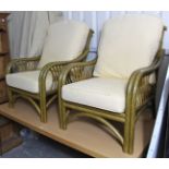 A pair of rattan conservatory armchairs with loose cushions to the seats & backs.