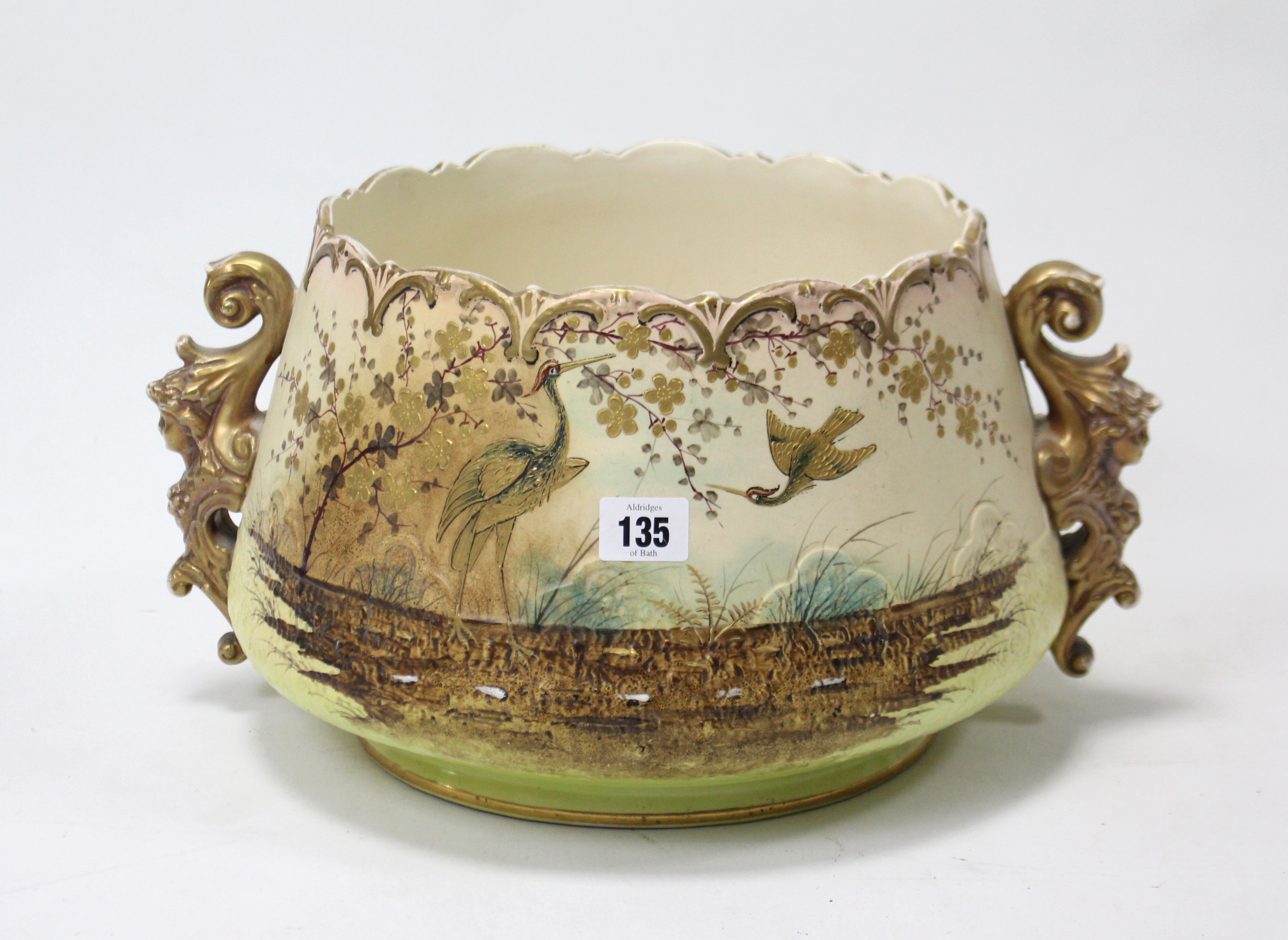 A pottery circular two-handled jardinière with painted wading bird & foliate design, 10” diam x