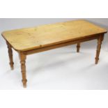 A pine kitchen table with rounded corners to the rectangular top, & on four turned legs, 76” x