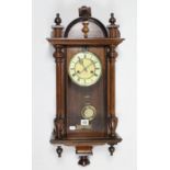 An early 20th century wall clock with two-part dial, striking movement, & in walnut case, 28” high.