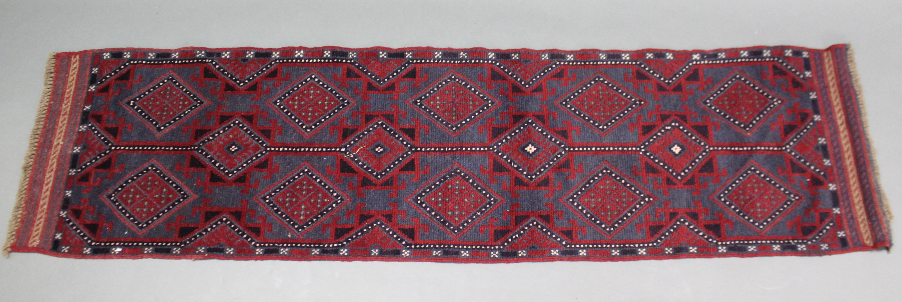 A Meshwari runner of madder ground, with all-over repeating geometric design in dark blue & ivory,