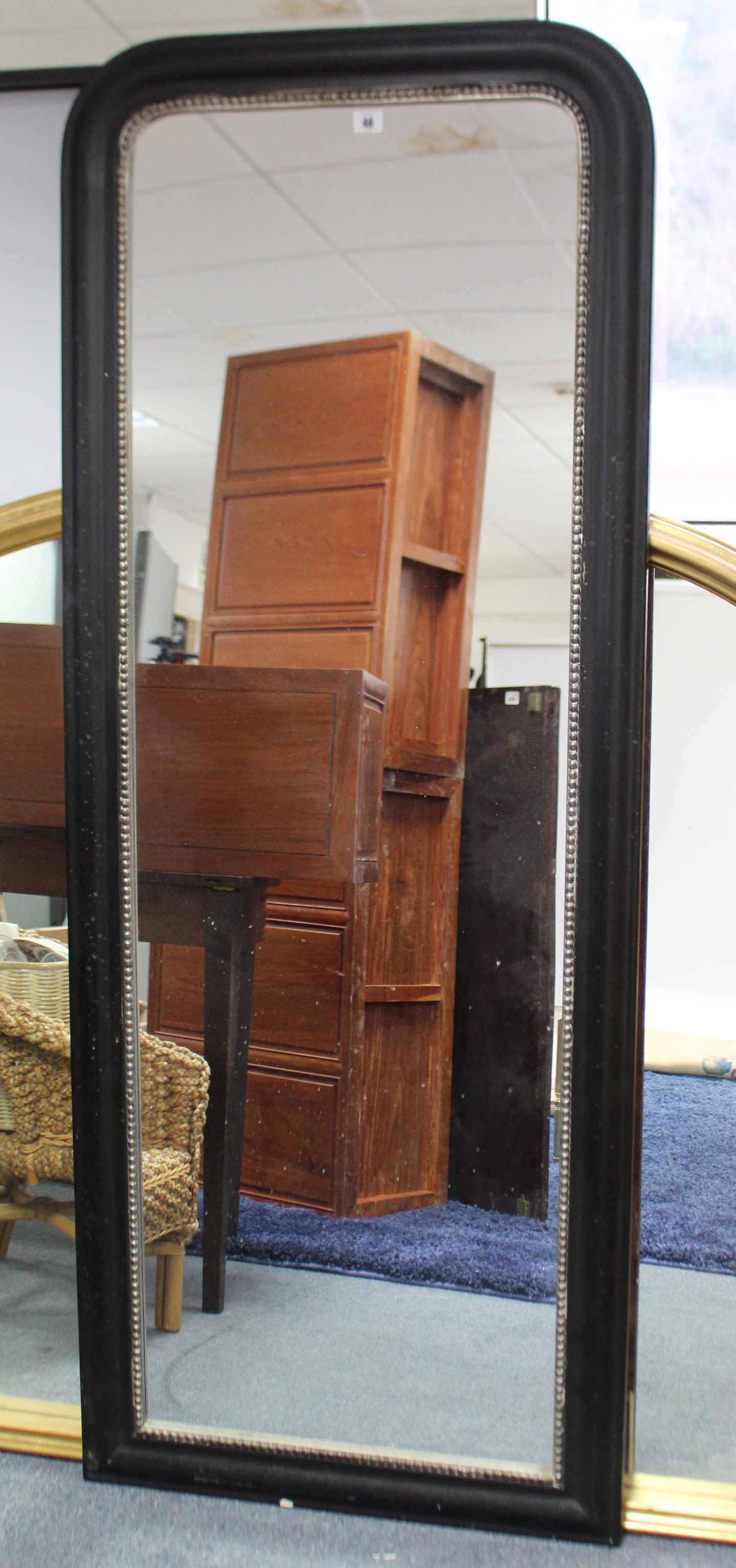 A large rectangular wall mirror in black-finish frame, with rounded top, & with beaded inner slip,