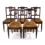 A set of five late 19th century carved walnut splat-back dining chairs with padded seats, & on