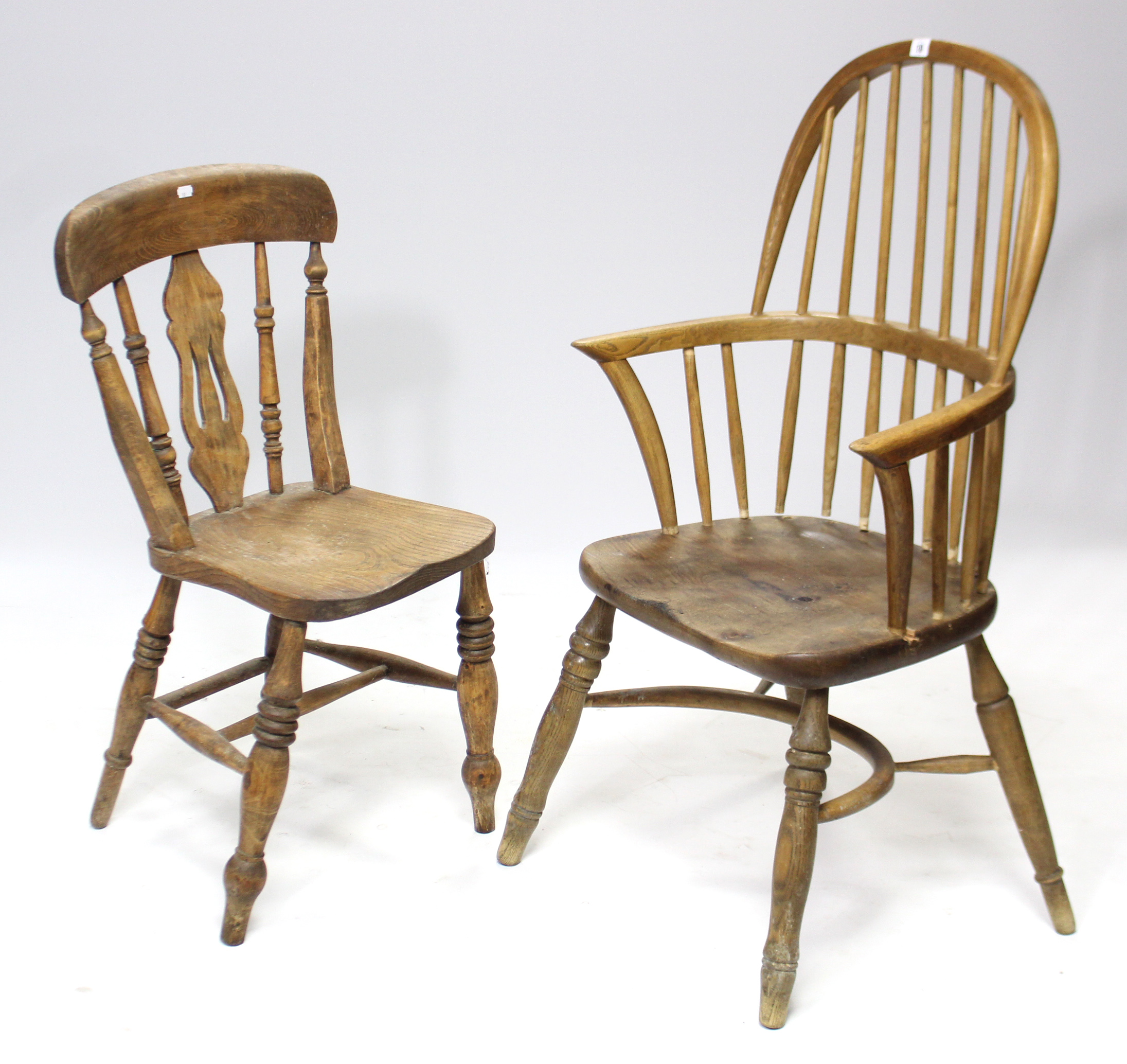 A Windsor-style elbow chair with spindles to the hooped back, with hard seat, & on turned legs