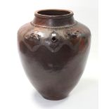An African large brown glazed pottery vessel of ovoid form, with all-over geometric design & with