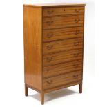A mahogany-finish upright chest fitted seven long graduated drawers with brass swing handles, & on