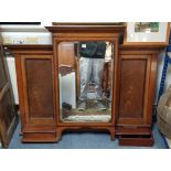 An early 20th century inlaid oak overmantel with cabinet to centre enclosed by bevelled mirror door,