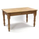 A pine kitchen table with rounded corners to the rectangular top, & on four turned legs, 54” x 34”.