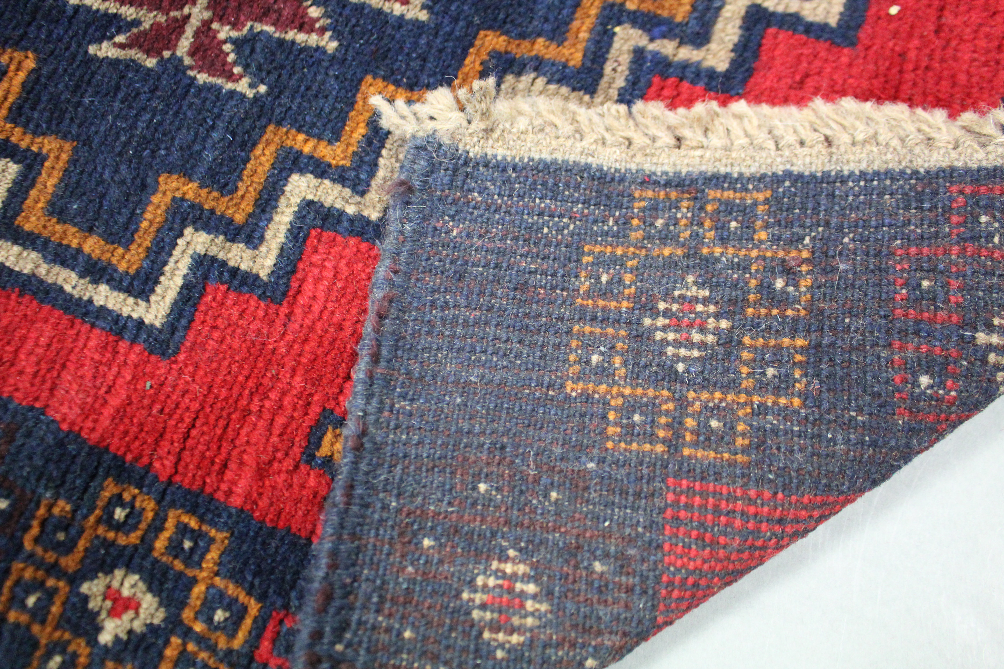 A Baluchi rug of dark blue, red & ivory ground with two central lozenges within a narrow border; - Image 2 of 2