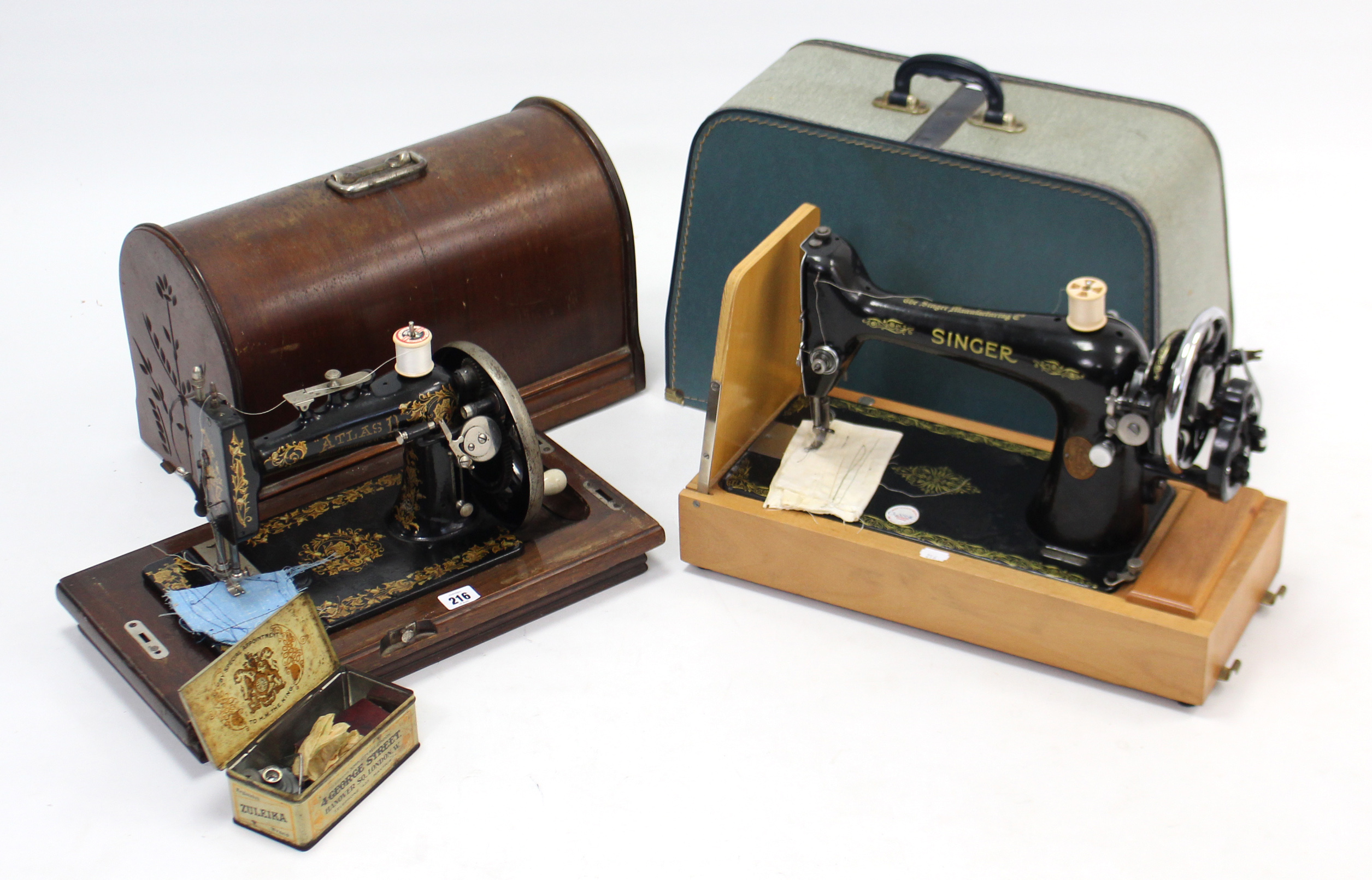 An Atlas hand sewing machine; & a Singer ditto, each with carrying case.