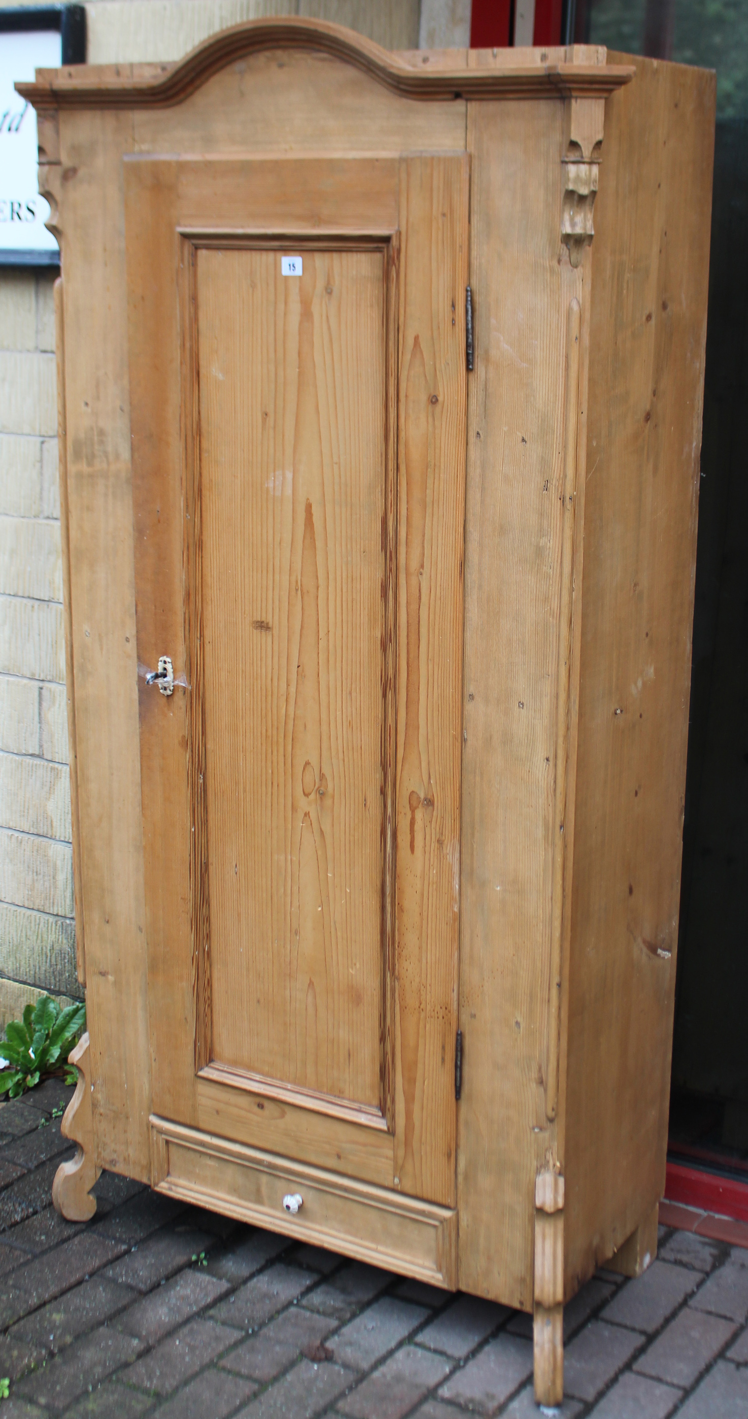 A continental-style tall pine hall cupboard with shaped & moulded cornice, & having fitted