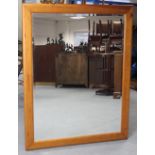 A large pine frame rectangular wall mirror, 54½” x 42½”; & a light oak frame overmantel mirror,