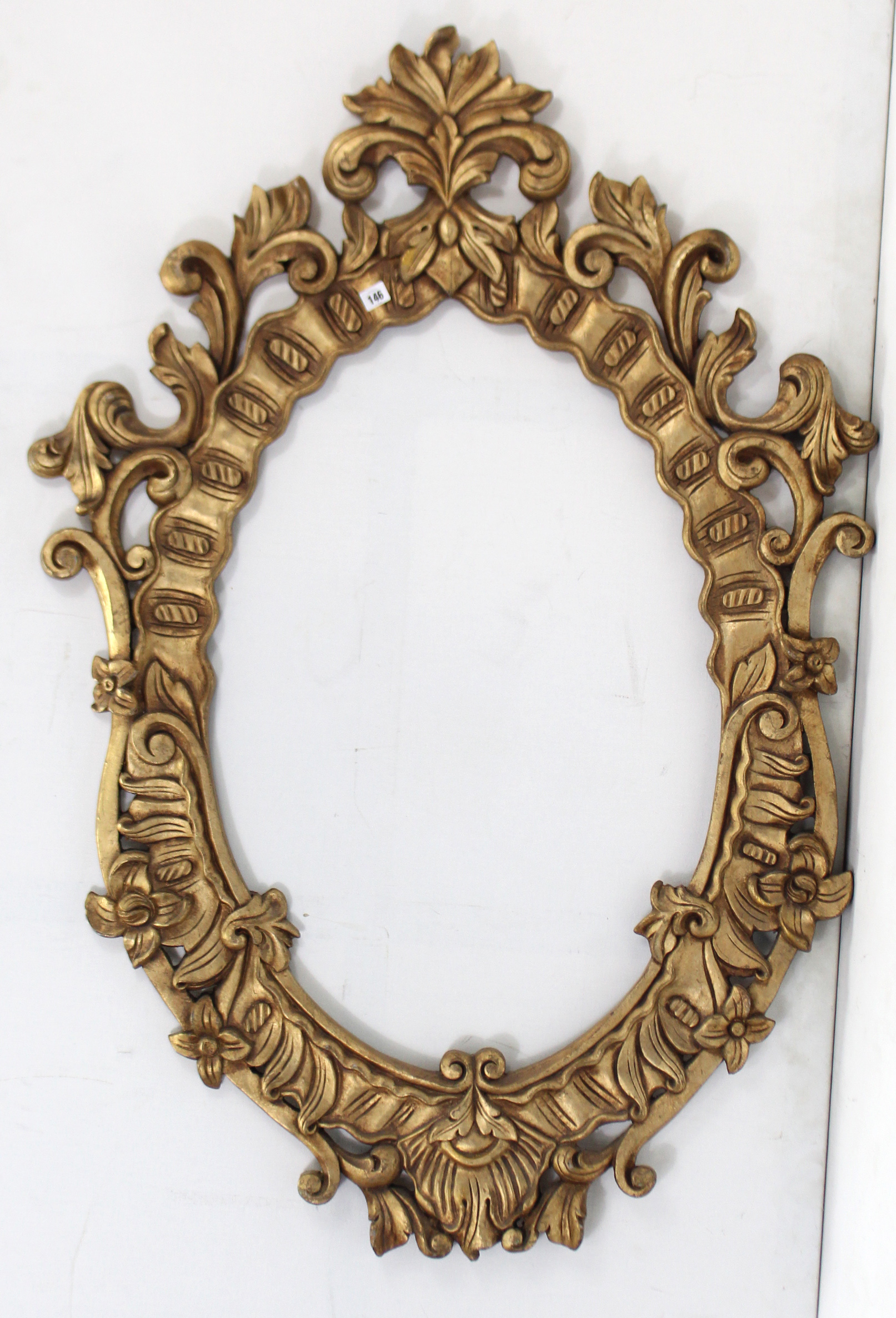 A 19th century-style gilt composition frame oval picture frame, with scroll border, 53½” x 40”.