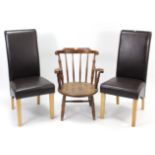 A spindle back low elbow chair with circular hard seat, & on turned legs with spindle stretchers;