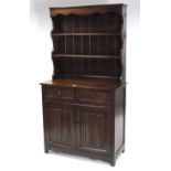 An oak dresser, fitted two open shelves to the panelled back, the base fitted two frieze drawers