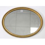 A gilt frame oval wall mirror with beaded edge & inset bevelled plate, 20­½” x 26”; & another oval