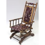 A late Victorian beech frame rocking chair with padded seat & back, & on sprung base.